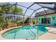 Screened-in pool area with lush landscaping, creating a private outdoor oasis at 18446 Burkholder Cir, Port Charlotte, FL 33948