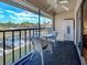 Enjoy condo balcony with wicker seating, table, ceiling fan, and peaceful views at 19505 Quesada Ave # Ee202, Port Charlotte, FL 33948