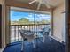 Cozy balcony with chairs, a table, and a view of the neighborhood at 19505 Quesada Ave # Ee202, Port Charlotte, FL 33948