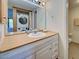 Bathroom vanity with sink, mirror, and storage, plus a stacked washer and dryer for convenience at 19505 Quesada Ave # Ee202, Port Charlotte, FL 33948