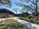Exterior shot of a screened patio with lush landscaping and a paved walkway at 19505 Quesada Ave # Ee202, Port Charlotte, FL 33948