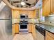 Well-equipped kitchen featuring stainless steel appliances, light wood cabinets, and granite countertops at 19505 Quesada Ave # Ee202, Port Charlotte, FL 33948