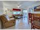 Cozy living room with tile flooring, comfortable seating, and access to outdoor balcony at 19505 Quesada Ave # Ee202, Port Charlotte, FL 33948