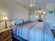 Comfortable main bedroom with ceiling fan, wood-look floors, and sliding mirrored closet doors at 19505 Quesada Ave # Ee202, Port Charlotte, FL 33948