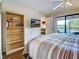 Spacious main bedroom with balcony access, TV, and a bookshelf provides lots of storage at 19505 Quesada Ave # Ee202, Port Charlotte, FL 33948