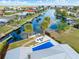 Waterfront home aerial view showcases a pool, dock, and surrounding scenic canals in a desirable neighborhood location at 1960 W Marion Ave, Punta Gorda, FL 33950