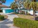 Beautiful single-story home with a lush lawn, swaying palm trees, and a winding driveway leading to the garage at 1960 W Marion Ave, Punta Gorda, FL 33950