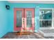 Inviting front entry with colorful double doors and a pineapple welcome mat at 1960 W Marion Ave, Punta Gorda, FL 33950