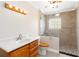 Modern bathroom with a tiled shower, glass block window, updated vanity, and decorative lighting at 212 Gulf Ave, Nokomis, FL 34275