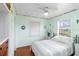 Bright bedroom featuring a queen-sized bed, wood floors, and nautical decor at 212 Gulf Ave, Nokomis, FL 34275