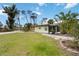 Cottage-style home features screened-in porch and gravel path surrounded by lush greenery at 212 Gulf Ave, Nokomis, FL 34275