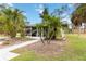 Charming home with lush landscaping, a sidewalk, and a screened-in front porch at 212 Gulf Ave, Nokomis, FL 34275