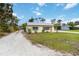 Cozy home with yellow exterior paint, gravel driveway, and grassy front yard at 212 Gulf Ave, Nokomis, FL 34275
