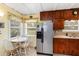 Functional kitchen with wood cabinets, stainless steel refrigerator, and cozy breakfast nook at 212 Gulf Ave, Nokomis, FL 34275