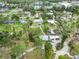 Aerial view of a residential neighborhood showcasing homes with large lots and mature trees, plus a glimpse of a nearby lake at 217 Palm E Ave, Nokomis, FL 34275