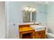 Modern bathroom with a custom wooden vanity and well lit mirror with tile backsplash at 217 Palm E Ave, Nokomis, FL 34275