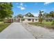 Inviting home featuring a long driveway and a carport, enhanced by mature trees and landscaping, creating curb appeal at 217 Palm E Ave, Nokomis, FL 34275
