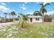 Charming single-story home with a light yellow exterior, a carport, and mature palm trees in the front yard at 217 Palm E Ave, Nokomis, FL 34275