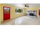 Bright living room featuring a large window, red door, ceiling fan, and a decorative brick fireplace at 217 Palm E Ave, Nokomis, FL 34275