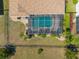 Aerial view of screened pool with chairs and meticulously landscaped yard with fence at 2304 Bonn Ct, Punta Gorda, FL 33983