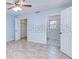 Spacious bedroom with tiled floors, ceiling fan, closet, and an open door to the ensuite bathroom at 23482 Moreland Ave, Port Charlotte, FL 33954