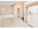 Open kitchen with white refrigerator and views to the bathroom at 23482 Moreland Ave, Port Charlotte, FL 33954