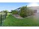 Screened-in patio and well-kept lawn with tropical landscaping at 2363 Jasmine Way, North Port, FL 34287