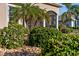 Close up showcasing lush, mature landscaping and decorative rock around the foundation of the home at 2363 Jasmine Way, North Port, FL 34287