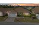 Inviting single-story home featuring a two-car garage, well-maintained lawn, and mature landscaping at 24909 Drumblaire Ct, Port Charlotte, FL 33980