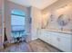 Bright bathroom featuring double vanities, wood look tile floors, and a large arched window at 25428 Islas Dr, Punta Gorda, FL 33955