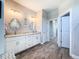 Bright bathroom with double sinks, wood look tile floors and entry to hallway at 25428 Islas Dr, Punta Gorda, FL 33955