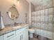 Bathroom featuring granite vanity, shower with tile surround and decorative mirror at 25428 Islas Dr, Punta Gorda, FL 33955