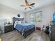 Bedroom with wood look tile floors, ceiling fan, and ample natural light at 25428 Islas Dr, Punta Gorda, FL 33955