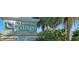 Entrance to Burnt Store Village deed-restricted community with lush landscaping and palm trees at 25428 Islas Dr, Punta Gorda, FL 33955