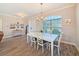 Elegant dining room with a white table set, arched window, and modern chandelier at 25428 Islas Dr, Punta Gorda, FL 33955