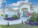 Inviting front entrance with lush landscaping, a decorative walkway, and a covered porch at 25428 Islas Dr, Punta Gorda, FL 33955