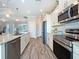 Bright kitchen featuring stainless steel appliances, stone countertops, and wood-look tile flooring at 25428 Islas Dr, Punta Gorda, FL 33955