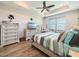 Bright main bedroom with a ceiling fan, wood-look tile, and ample natural light at 25428 Islas Dr, Punta Gorda, FL 33955