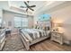 Comfortable main bedroom featuring wood-look tile, tray ceiling, and accent decor at 25428 Islas Dr, Punta Gorda, FL 33955