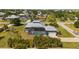 Aerial view of a grey single-Gathering home with a large yard, screened pool, and a two-car garage at 303 W Grace St, Punta Gorda, FL 33950