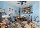 A cozy blue bedroom featuring a music setup, floating shelves, and a comfortable seating area at 303 W Grace St, Punta Gorda, FL 33950