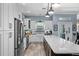 Bright kitchen featuring white cabinets, a farmhouse sink, stainless steel appliances, and a large island at 303 W Grace St, Punta Gorda, FL 33950