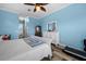 Large main bedroom featuring a ceiling fan, blue walls, plank flooring, and access to the ensuite bathroom at 303 W Grace St, Punta Gorda, FL 33950