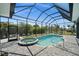 Enclosed pool and spa area with beautiful tile, outdoor seating, and mature landscaping at 303 W Grace St, Punta Gorda, FL 33950