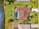 Aerial view of a home with a screened-in pool, manicured lawn, and waterfront access at 32 Long Meadow Ln, Rotonda West, FL 33947