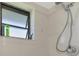 Bathroom featuring a shower head, a window, and a tiled wall at 32 Long Meadow Ln, Rotonda West, FL 33947