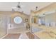 Large bathroom features a soaking tub, vanity with dual sinks, and a separate glass enclosed shower at 32 Long Meadow Ln, Rotonda West, FL 33947