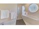 Bathroom featuring a round window, a shower with glass doors and a soaking tub at 32 Long Meadow Ln, Rotonda West, FL 33947