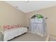 Light bedroom with a daybed, decorative pillows, and arched window at 32 Long Meadow Ln, Rotonda West, FL 33947