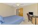 Cozy bedroom featuring a desk, chair, and a light blue bed; ideal for a home office or guest room at 32 Long Meadow Ln, Rotonda West, FL 33947